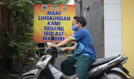 Pengendara sepeda motor melintasi gang perkampungan yang diberlakukan karantina di RT 007/RW 005, Utan Kayu Selatan, Jakarta Timur, Jumat (11/6/2021). Pemberlakuan karantina tersebut dilakukan setelah ditemukannya 22 kasus COVID-19 dari klaster keluarga.