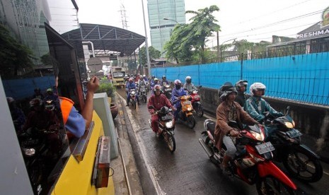   Pengendara sepeda motor memasuki gerbang pintu Tol Lenteng Agung Dua, Jakarta, Senin (13/1). (Antara/M Agung Rajasa)