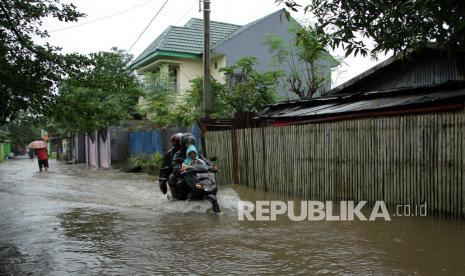 Pengendara sepeda motor menerobos banjir di Makassar (ilustrasi). Dampak cuaca ekstrem memicu beberapa titik di Kota Makassar mengalami genangan. 