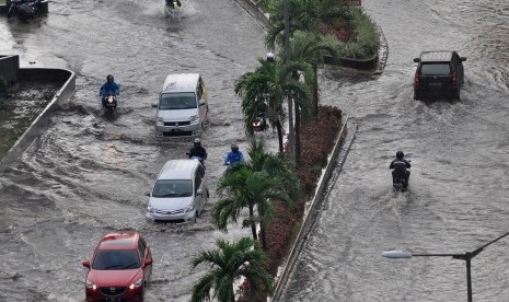 Pengendara sepeda motor menerobos banjir di jalan raya Lodan, Ancol, Jakarta Utara, Kamis (21/4). 