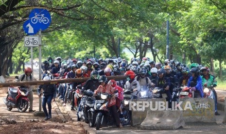 Pengendara sepeda motor menerobos portal yang dipasang di jalur sepeda di kawasan Banjir Kanal Timur (BKT), Kawasan Cipinang, Jakarta, Rabu (20/7).Republika/Yasin Habibi