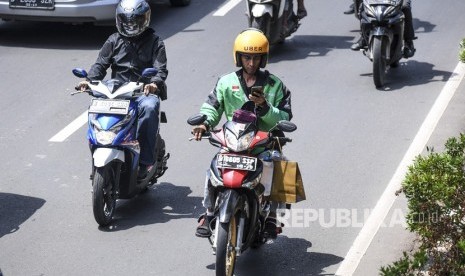 Pengendara sepeda motor mengamati aplikasi GPS (pelacak jalan) di gawainya saat berkendara di Jalan Rasuna Said, Kuningan, Jakarta, Kamis (7/2/2019). 