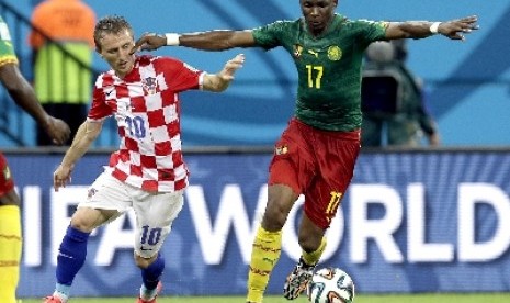 Penggawa timnas Kamerun Stephane Mbia berebut bola dengan gelandang timnas Kroasia, Luka Modric.