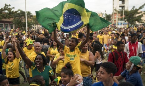  Penggemar bola di Brasil menonton kemenangan tim nasionalnya negaranya melawan Serbia dari kawasan kumuh Munguinhos di Rio de Janeiro, Kamis (28/6).