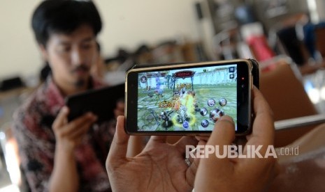 Penggemar Game bermain game di handphone.  ilustrasi