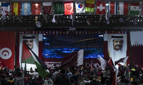  Penggemar sepak bola Palestina menonton siaran langsung pertandingan pembukaan Piala Dunia 2022 antara Qatar dan Ekuador, di layar raksasa yang dipasang di antara potret Emir Qatar Sheikh Tamim bin Hamad al-Thani (L) dan ayahnya mantan Emir Sheikh Hamad bin Khalifa Al Thani , di gimnasium tertutup di Kota Gaza, Ahad, 20 November 2022. 