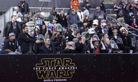 Penggemar Star Wars mengangkat helm mereka saat penayangan perdana Star Wars: Force Awakens di Los Angeles, Senin waktu AS (14/12).