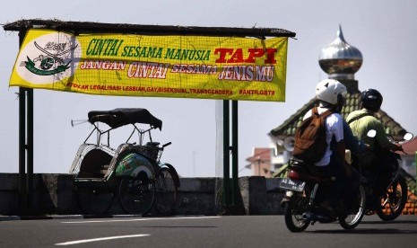 Pengguna jalan melintas di dekat spanduk berisi penolakan kepada kelompok Lesbian, Gay, Biseksual dan Transgender (LGBT) di Yogyakarta, Rabu (24/2)