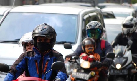 Pengguna kendaraan bermotor menggunakan masker guna mengantisipasi polusi yang terhirup di Jalan Rasuna Said, Jakarta Selatan, Kamis (12/6).