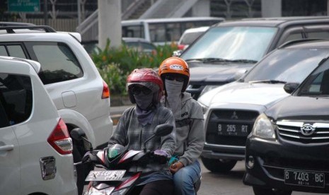 Pengguna kendaraan bermotor menggunakan masker guna mengantisipasi polusi yang terhirup di Jalan Rasuna Said, Jakarta Selatan.