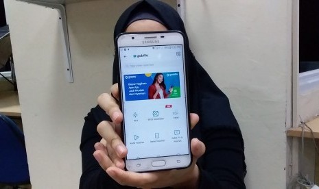 Pengguna menunjukkan aplikasi Gopay. Badan Usaha Milik Daerah (BUMD) DKI Jakarta, PTTransportasi Jakarta (TransJakarta) berkolaborasi dengan PT GoTo Gojek Tokopedia Tbk (Grup GoTo) untuk menggunakan layanan dompet elektronik GoPay sebagai opsi pembayaran di aplikasi mobile Tije.