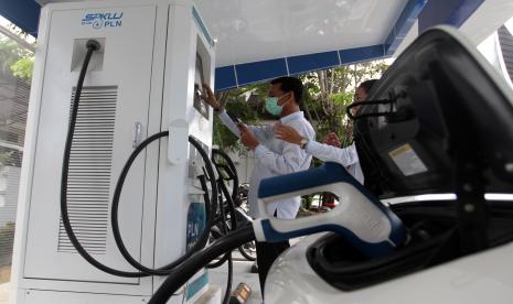 Pengguna mobil listrik mengisi daya di Stasiun Pengisian Kendaraan Listrik Umum (SPKLU) di Padang, Selasa (26/7/2022). Salah satu pendorong penerapan kendaraan listrik atau electric vehicle (EV) adalah adanya fasilitas pengisian baterai EV yang tersebar di sejumlah titik.