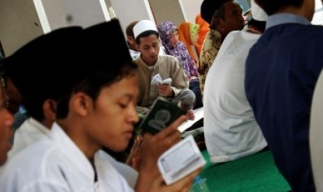 Penghafal Alquran atau hafidz melantunkan ayat suci di komplek makam Pondok Pesantren Tebuireng, Jombang, Jawa Timur, Sabtu (26/12). 