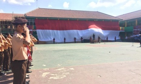 Pengibaran bendera merah putih berukuran raksasa saat upacara peringatan Hari Kemerdekaan ke-74 Republik Indonesia di SMKN 1 Kabupaten Garut, Sabtu (17/8). 