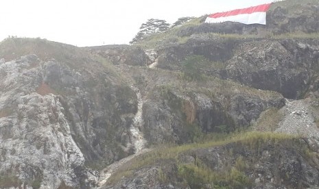 Pengibaran bendera Merah Putih raksasa dilakukan di puncak Bukit Karang Putih, area pertambangan PT Semen Padang, Kamis (17/8). Pengibaran dilakukan dengan teknik vertical rescue oleh TRC Semen Padang.