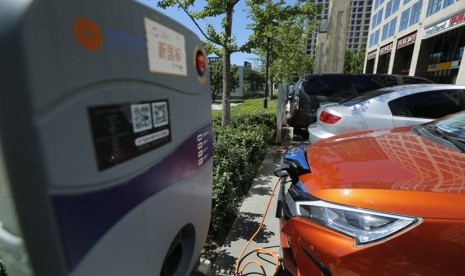 Pengisian kendaraan mobil berbahan bakar listrik di luar sebuah apartemen di Beijing, China, 11 September 2017. Penjualan mobil penumpang di China naik 2,4 persen pada Desember. 