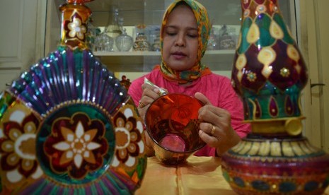 Pengrajin membuat kerajinan gelas lukis di industri rumahan Bluru, Sidoarjo, Jawa Timur, Selasa (10/11).