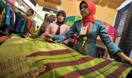 Pengrajin menunjukan kain songket karyanya, saat pameran Sawahlunto International Songket Carnival (SISCa) 2017, di Sawahlunto, Sumatera Barat, Jumat (25/8). Pameran tersebut menampilkan songket karya pengrajin lokal dan karya dari Riau, Palembang, Kalimantan, serta sejumlah daerah lainnya di nusantara. 