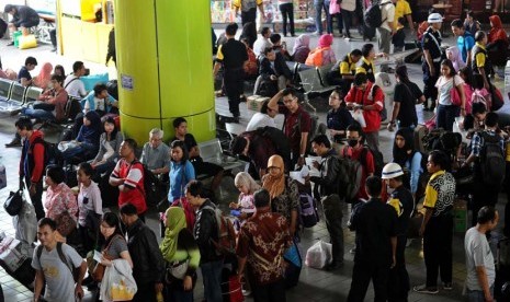 Penguna jasa kereta api mengantre saat akan memasuki pintu masuk selatan stasiun Gambir, Jakarta, Jumat (25/7). 