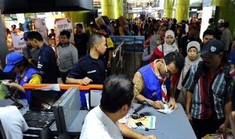  Penguna jasa kereta api mengantri saat akan memasuki pintu masuk selatan stasiun Gambir, Jakarta, Jumat (25/7)