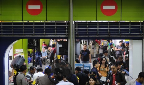 Penguna jasa kereta api mengantri saat akan memasuki pintu masuk selatan stasiun Gambir, Jakarta, Jumat (25/7) 