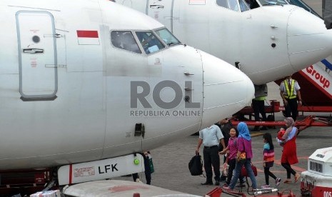 Penguna jasa penerbangan melintas saat akan menaiki pesawat di terminal 1B keberangkatan dalam negeri bandara Internasional Soekarno Hatta, Tangerang, Banten, Selasa (14/7).