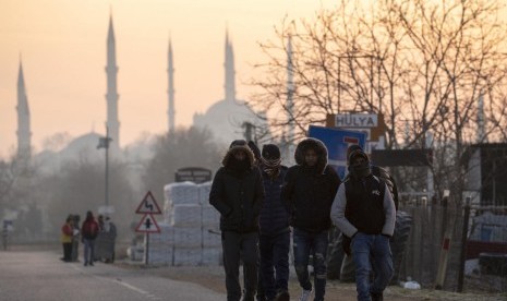 Pengungsi berjalan di perbatasan Turki-Yunani pada Ahad (1/3). Turki memutuskan untuk tak lagi menghalangi arus imigran ke Eropa.(Erdem Sahin/EPA)