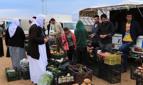 Pengungsi dari agama minoritas Yazidi membeli sayuran di Kamp Sharya di Duhok, Irak, Selasa (29/10).