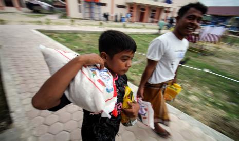 Pengungsi etnis rohingya membawa beras dan bingkasan saat pembagian zakat di tempat penampungan sementara BLK Desa Meunasah Mee, Lhokseumawe, Aceh, Ahad (1/5/2022). Bank Dunia akan menggelontorkan 30 miliar dolar AS untuk menahan krisis pangan yang disebabkan invasi Rusia di Ukraina. 