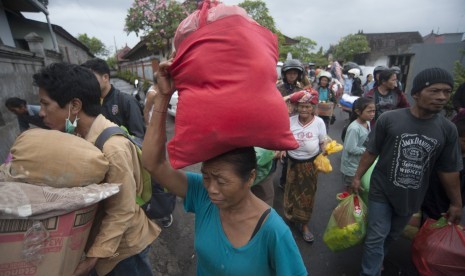 Pengungsi Gunung Agung asal Desa Muncan membawa barangnya saat mereka diantarkan ke kampungnya dari tempat penampungan sementara di Klungkung, Bali, Sabtu (7/10).