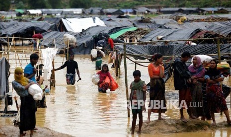 Pengungsi meninggalkan kamp pengungsi Rohingya yang terendam banjir di Cox