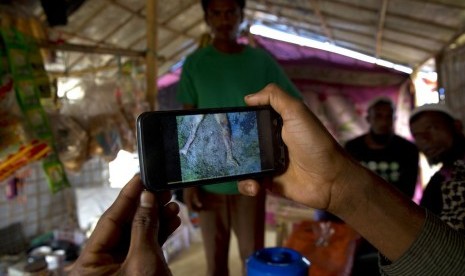 Pengungsi Muslim Rohingya Mohammad Karim menunjukkan video ponsel pembunuhan massal di Gu Dar Pyin di kamp pengungsi Kutupalong, Bangladesh.