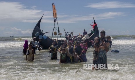 Pengungsi Rohingya berjalan menuju daratan perairan setelah mereka tiba dari Myanmar ke Bangladesh di Shah Porir Dwip, Bangladesh Kamis, (14/9).