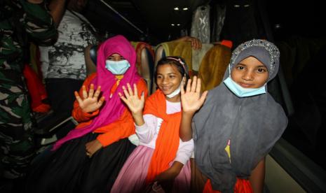 Pengungsi Rohingya melambaikan tangan saat akan diberangkatkan dari tempat penampungan Balai Latihan Kerja (BLK) Desa Meunasah Mee Kandang, Lhokseumawe, Aceh, Rabu (18/5/2022) malam. Sebanyak 81 jiwa sisa pengungsi Rohingya di penampungan BLK Lhokseumawe dan penampungan di Kabupaten Bireuen itu dipindahkan ke Pekanbaru untuk mengikuti program penanganan pengungsi lintas negara oleh International Organization for Migration (IOM).