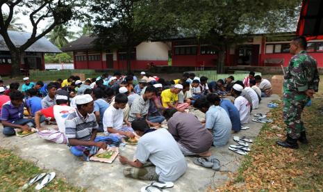  Pengungsi Rohingya sarapan pagi di tempat penampungan sementara yang disediakan oleh pemerintah daerah Aceh, di Pidie, Aceh, Selasa (28/12/2022). Polisi setempat mengatakan bahwa 174 migran etnis Rohingya mendarat di Pantai Laweung Pidie, Provinsi Aceh di Indonesia pada 26 Desember, setelah dilaporkan berlayar selama berminggu-minggu di laut. Menurut pernyataan yang dikeluarkan pada 27 Desember oleh Badan Pengungsi PBB (UNHCR), lebih dari 200 orang dibawa ke pantai dengan aman di barat laut Indonesia selama beberapa hari terakhir.  Pengungsi Rohingya yang mayoritas wanita dan anak-anak, diselamatkan dan diturunkan oleh nelayan Indonesia dan pihak berwenang setempat.