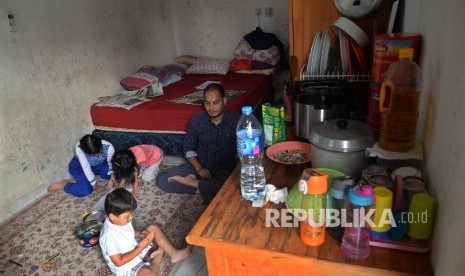 Pengungsi RohingyaKarimullah bercengkerama dengan anaknya di tempat kos di Jalan Karet Pedurenan, Jakarta Selatan, Senin (4/9)