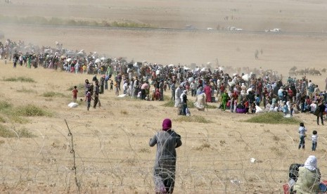 Pengungsi Suriah menuju perbatasan Turki di dekat Kota Kobani.