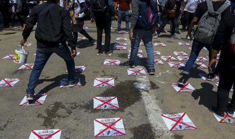 Pengunjuk rasa anti-kudeta berjalan di jalan dengan gambar Panglima Tertinggi, Jenderal Senior Min Aung Hlaing, di Yangon, Myanmar, Kamis, 4 Maret 2021. Demonstran di Myanmar yang memprotes kudeta militer bulan lalu kembali ke jalan-jalan Kamis, tanpa gentar oleh pembunuhan sejumlah orang pada hari sebelumnya oleh pasukan keamanan. 