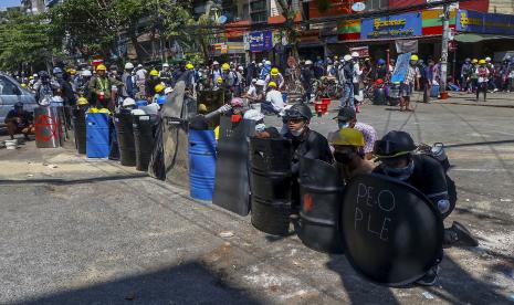  Pengunjuk rasa anti-kudeta berlindung di balik perisai darurat selama demonstrasi di Yangon, Myanmar Kamis, 4 Maret 2021. Demonstran di Myanmar yang memprotes kudeta militer bulan lalu kembali ke jalan-jalan pada hari Kamis, tidak gentar dengan pembunuhan sedikitnya 38 orang pada hari sebelumnya oleh pasukan keamanan. 