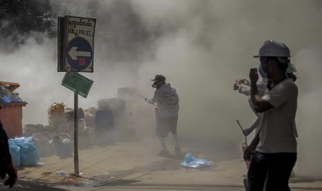  Pengunjuk rasa anti-kudeta melepaskan alat pemadam kebakaran untuk melawan dampak gas air mata yang ditembakkan oleh polisi anti huru hara selama demonstrasi di Yangon, Myanmar, Kamis, 4 Maret 2021. Demonstran di Myanmar yang memprotes kudeta militer bulan lalu kembali ke jalan pada hari Kamis, tidak gentar oleh pembunuhan sedikitnya 38 orang pada hari sebelumnya oleh pasukan keamanan.