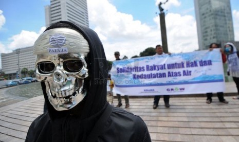 Pengunjuk rasa dari Koalisi Rakyat Untuk Hak Atas Air (Kruha) beraksi teatrikal dalam rangka Hari Air Sedunia di Bundaran HI, Jakarta, Sabtu (22/3). ( Republika/Aditya Pradana Putra)