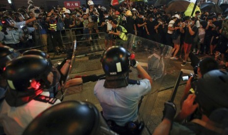 Pengunjuk rasa Hong Kong bergerak mundur saat ditekan polisi dalam protes menentang RUU ekstradisi di Hong Kong, Ahad (77). 