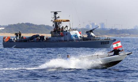 Pengunjuk rasa Lebanon di atas perahu motor membawa bendera nasional mereka saat mereka berlayar di depan kapal Angkatan Laut Israel. Lebanon dan Israel siap untuk menyepakati perjanjian perbatasan maritim yang selama ini mereka persengketakan. 