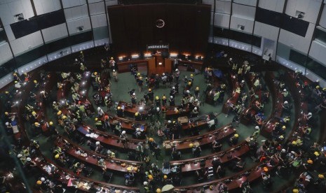 Pengunjuk rasa memasuki dan berkumpul di ruang pertemuan Dewan Legislatif di Hong Kong, Senin (1/7).