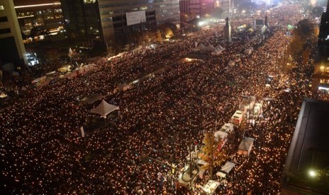 Pengunjuk rasa membawa lilin dalam aksi anti-pemerintah menuntut Presiden Korea Selatan Park Geun-Hye mengundurkan diri karena skandal korupsi di pusat kota Seoul, Korea Selatan, November 2016. 