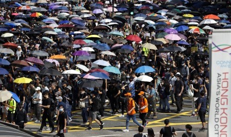 Pengunjuk rasa membawa payung dalam demonstrasi di Hong Kong, Ahad (20/10).