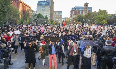 Pengunjuk rasa memegang poster besar dalam aksi 'Love Rally' menentang terpilihnya Donald Trump sebagai presiden. Massa beraksi di Washington Square Park menuju Union Square di New York, (11/111).