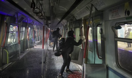 Pengunjuk rasa mencoret-coret kereta yang diparkir di stasiun Chinese University MTR di Hong Kong, Rabu (13/11).