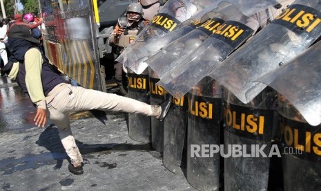 Pengunjuk rasa menendang barikade personel Polda Sulawesi Tenggara saat aksi menuntut penuntasan kasus kematian mahasiswa di depan Polda Sulawesi Tenggara, Kendari, Sulawesi Tenggara, Selasa (22/10/2019). 