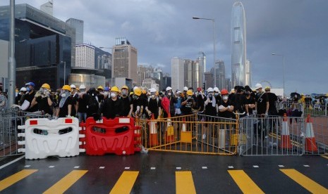 Pengunjuk rasa mengenakan masker ketika mereka berusaha memblokir jalan menuju lokasi peringatan kembalinya Hong Kong ke China di Hong Kong, Senin (1/7).